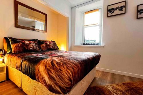 a bedroom with a large bed with a large animal blanket at 1-Bed Apartment Sleeps 2 -Free Parking -WiFi & Tv in Dundee