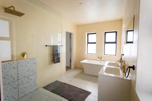 een badkamer met een bad en een wastafel en een ligbad bij Serenity on Sidwell in George