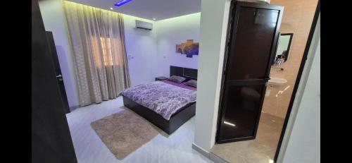 a small bedroom with a purple bed and a mirror at Thiam IMMO in Nouakchott