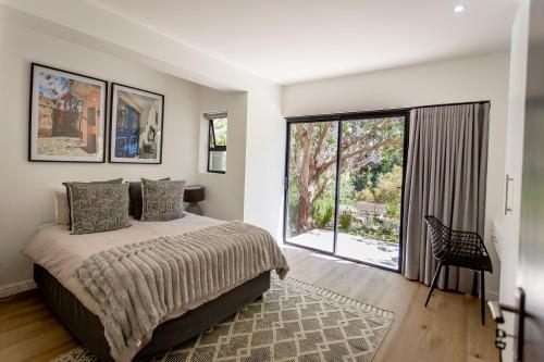 een slaapkamer met een bed en een groot raam bij Serenity on Sidwell in George