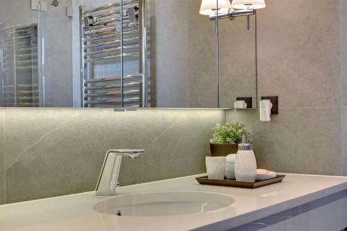 a bathroom with a sink and a mirror at NEMO Deluxe - 3 min od plaży i parking by Lion Apartments Sopot in Sopot