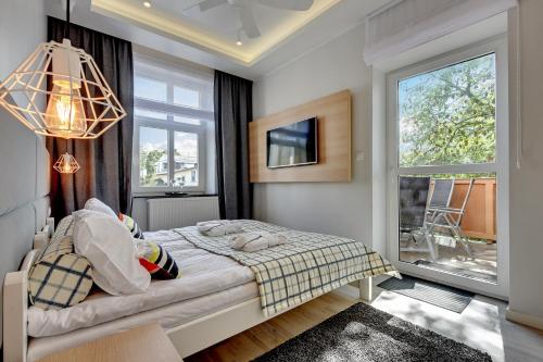 1 dormitorio con cama y ventana en Lion Apartments - NEMO Family 2 Bedr Apartment with parking, terrace and 3 min from the beach, en Sopot