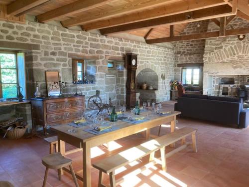 a living room with a table and a stone wall at La maison des Florentins La Monédière in Chaumeil