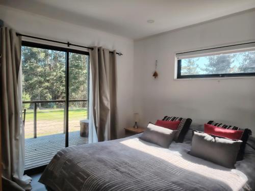 a bedroom with a large bed and a large window at Cabaña Matanzas tinaja privada vista al bosque in Boca Pupuya