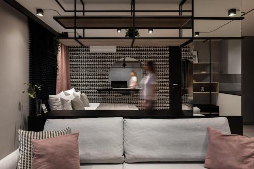 ein Wohnzimmer mit einer Couch und einer Person im Hintergrund in der Unterkunft Kraków Wawrzyńca Suites by Downtown Apartments in Krakau