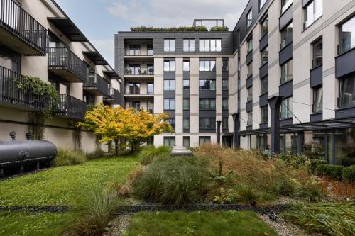 ein Mehrfamilienhaus mit einem Garten davor in der Unterkunft Kraków Wawrzyńca Suites by Downtown Apartments in Krakau