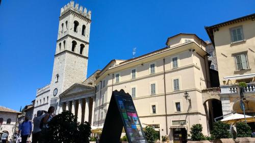 a tall clock tower next to a building at Camere Calocci in Assisi