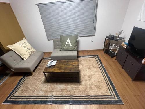 a living room with a couch and a coffee table at コーポ川端 in Goshogawara
