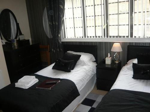 a bedroom with two beds and a window at The Georgian Guesthouse in Alnwick