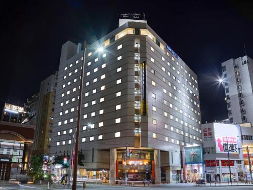 a large building with lights on in a city at night at APA Hotel Fukuoka Watanabedori Ekimae EXCELLENT in Fukuoka