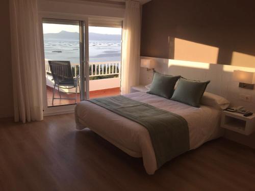 um quarto com uma cama e vista para o oceano em Hotel Mirador Ría de Arosa em Reboredo