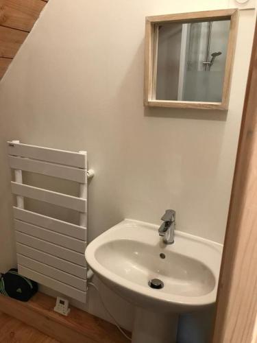 a bathroom with a white sink and a mirror at La maison de Baptiste La Monédière in Chaumeil