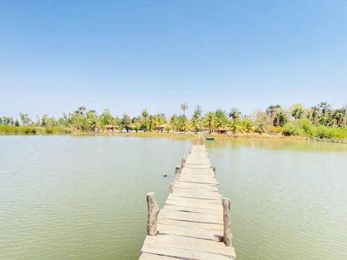 un quai en bois au milieu d'un lac dans l'établissement Wunderland River Lodge, à Kubuni