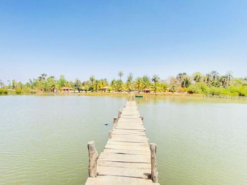 un quai en bois au milieu d'un lac dans l'établissement Wunderland River Lodge, à Kubuni