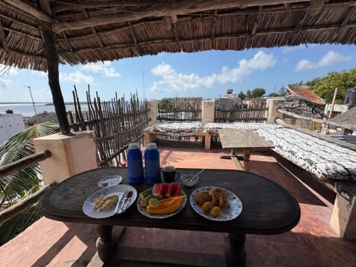 拉穆Wildebeeste Lamu的阳台上的一张桌子上摆着两盘食物