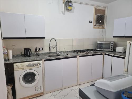 a kitchen with a sink and a washing machine at Adream partment in Luxor in Luxor