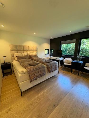 Un dormitorio con una cama grande y un escritorio. en Lillestrøm , the studio flat, en Kjeller