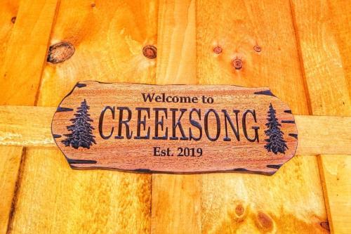 a wooden sign hanging on a wooden door at WiFi & Waterfront - Creeksong -Red River Gorge KY in Rogers