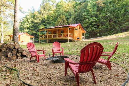 a group of four red chairs in front of a cabin at WiFi & Waterfront - Creeksong -Red River Gorge KY in Rogers