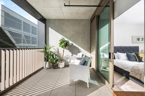 einen Balkon mit einem Bett und einem Sofa in der Unterkunft Geelong Central Apartment with Short & Long Stays in Geelong