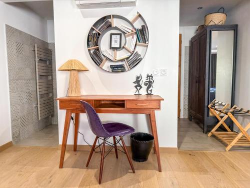 a desk with a purple chair and a mirror at Origines in Tautavel