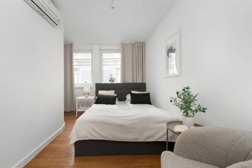 a white bedroom with a bed and a couch at Family Apartment with 3 Bedrooms & Air Conditioning in the Centre of Wrocław by Noclegi Renters in Wrocław