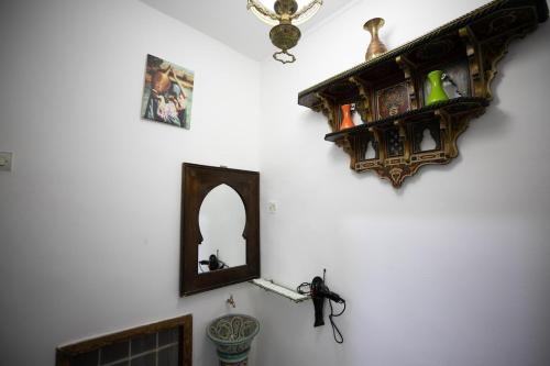 un miroir et une étagère sur un mur dans l'établissement Dar El Kendil, à Fès
