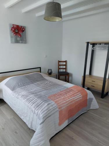 a bedroom with a bed and a chair in it at Les jonquilles in Forest-Montiers