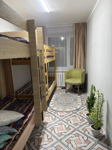a room with two bunk beds and a chair at Hostel Qadam in Kokshetau