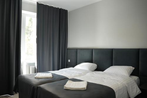 Un dormitorio con una cama grande con dos toallas encima. en Elata Aparts, en Skhidnytsya