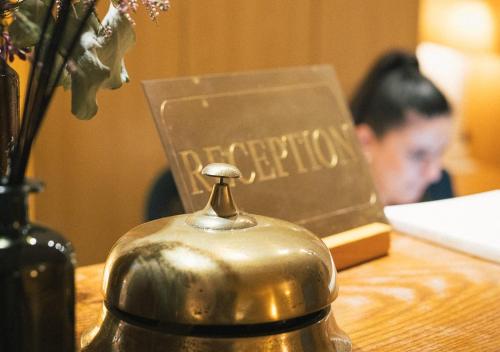 a tea kettle sitting on a table next to a book at Auberge du Rédier - Logis Hôtels in Colomars
