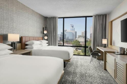 a hotel room with two beds and a large window at Sheraton Charlotte Hotel in Charlotte