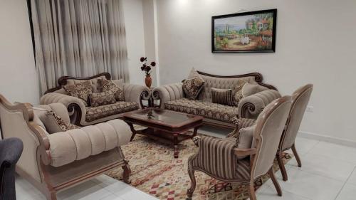 un salon avec des canapés, une table et des chaises dans l'établissement شقه في حي الراهبات, à Irbid