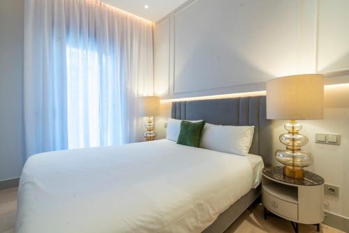マドリードにあるLuxury Villa Madrid 10 paxの大きな白いベッドとランプのある寝室