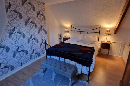 a bedroom with a bed and a wall with a mural at 3 Bed Cottage Sleeps 6 - Enclosed Patio -Fireplace in Beaucoudray
