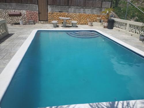a large swimming pool with blue water in a yard at Bayview Luxury Retreats in Montego Bay