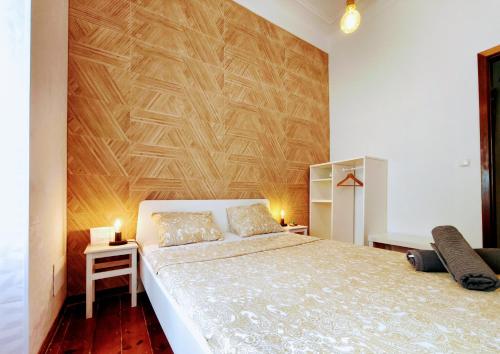 a bedroom with a large bed with a wooden wall at Areeiro Urban Rooms in Lisbon