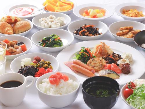 una mesa llena de platos de diferentes tipos de alimentos en APA Hotel Kokura Ekimae, en Kitakyushu