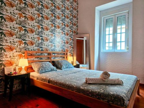 a bedroom with a large bed with a floral wallpaper at Areeiro Urban Rooms in Lisbon