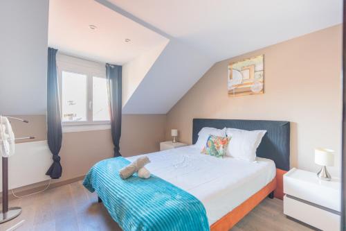 a bedroom with a bed with a teddy bear on it at Le 3 de Coeur Annecy in Annecy
