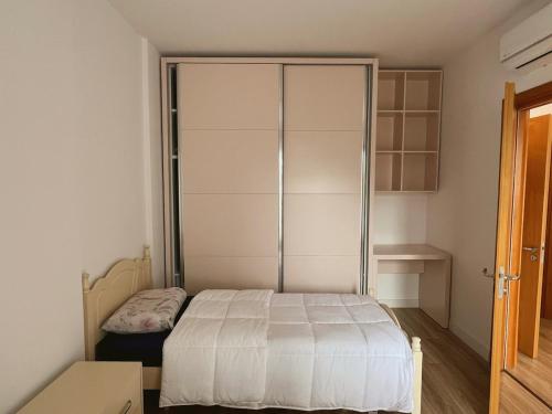 a small bedroom with a bed and a closet at Up in Tirana Apartment in Tirana