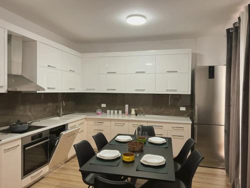 a kitchen with a black table and chairs in it at Up in Tirana Apartment in Tirana