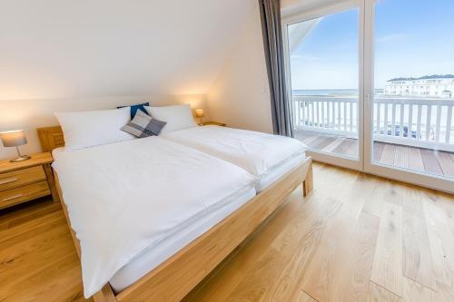 a bedroom with a large bed and a large window at Ferienhaus Auf der Ostsee in Kappeln
