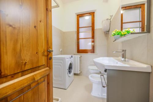 a bathroom with a sink and a washing machine at Villa Asia Deluxe in Castiglione del Lago