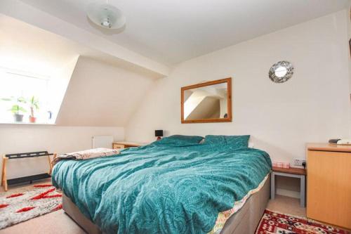 a bedroom with a large bed with a blue blanket at Your 4 Bedroom Townhouse - Superking Bed in Stamford