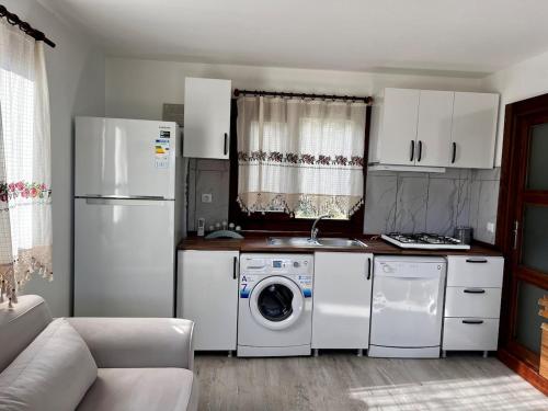 eine Küche mit einem Kühlschrank, einer Waschmaschine und einem Trockner in der Unterkunft Olympos NaR Village Nature,Sea and You in Kumluca