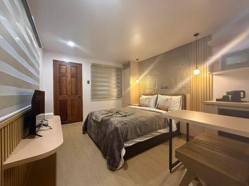 a bedroom with a bed and a desk in it at Inngo Tourist Inn in El Nido