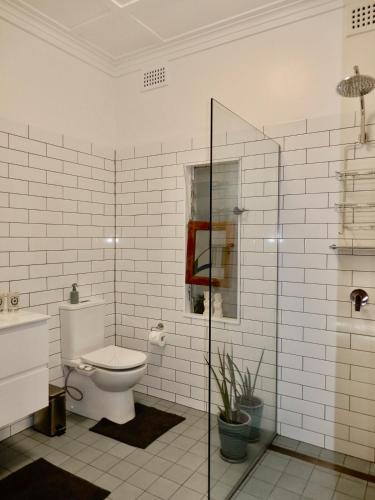 a bathroom with a toilet and a glass shower at Women Only Guesthouse in Mullumbimby