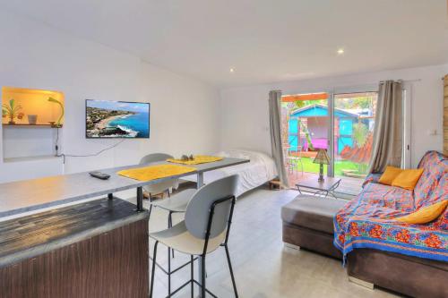 a living room with a table and a couch at Ti Kaz Maloya - Saint Paul in Saint-Paul