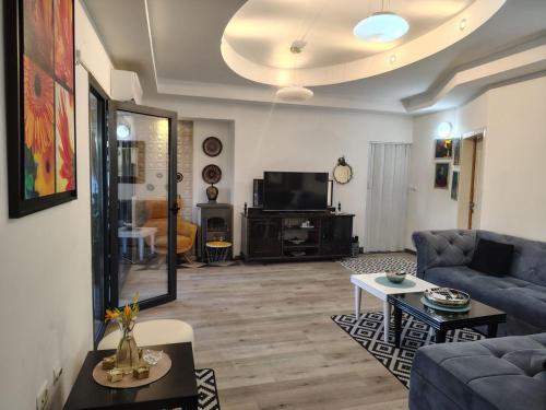 a living room with a blue couch and a tv at Katata Apartment Spacious House Floor with Terraces, 3 Bedrooms, Parking,Wi-Fi in Podgorica